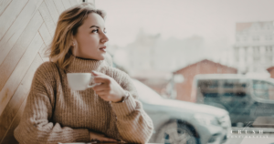 A woman sitting in a cafe thinking.